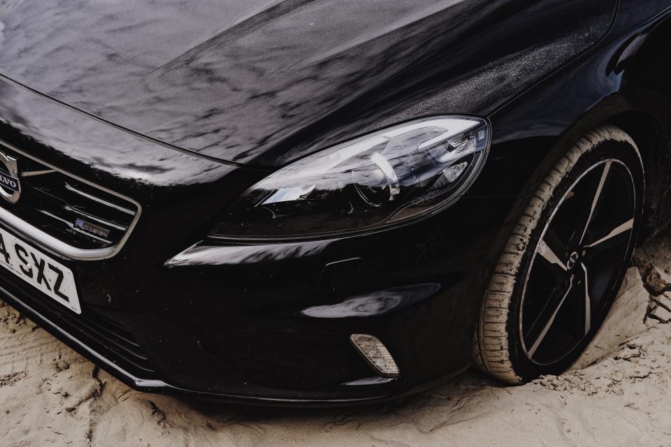 A glossy black sedan with clean, straight body panels after paintless dent repair